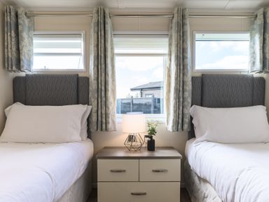 A bedroom with two beds and a nightstand at Helvellyn (Pet) in Penrith
