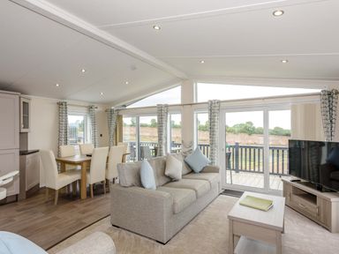 A living room with a sofa and dining area at Helvellyn (Pet) in Penrith