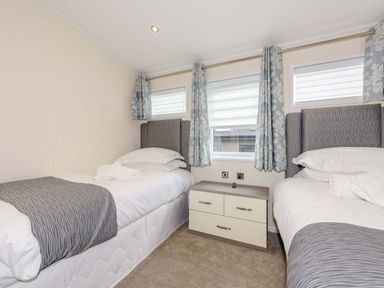 A bedroom with two beds and a drawer unit at Helvellyn (Pet) Penrith