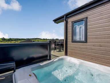 An outdoor area with a hot tub and seating at Scaféll in Penrith
