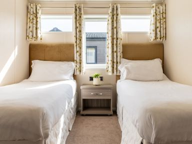 A bedroom with two beds and a bedside table at Scaféll in Penrith