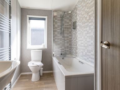 A bathroom with a bathtub and toilet at Scaféll in Penrith