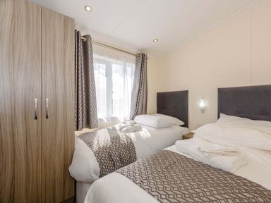 A bedroom with two beds and a wardrobe at Scaféll in Penrith
