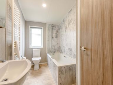 A bathroom with a bathtub and a toilet at Scaféll in Penrith