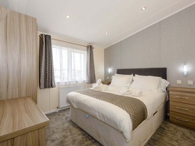 A bedroom with a bed and nightstands at Scaféll in Penrith