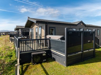 A deck area with a hot tub and seating at Scaféll (Pet) Penrith