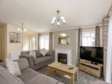 A living room with a television and coffee table at Scaféll (Pet) in Penrith
