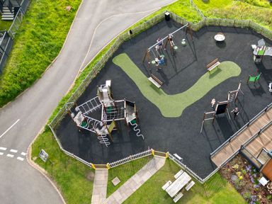 A playground with swings, slides, and benches at Scaféll (Pet) Penrith