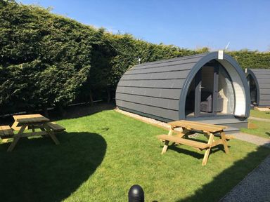 A pod with picnic tables and grass area at Pod 4 (No Pets) in Carnforth