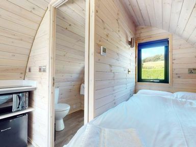 A bedroom with a bed, microwave, and a toilet at Pod 9 (No Pets) Carnforth
