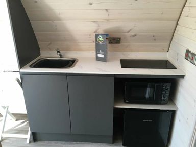 A kitchen with a sink, microwave, and fridge at Pod 9 (No Pets) Carnforth