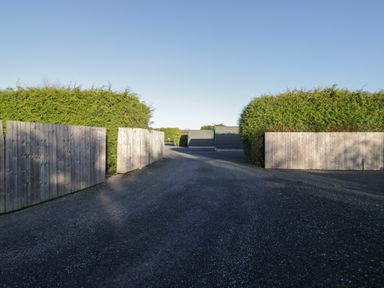 An outdoor area with a gravel road and wooden gates at Pod 9 (No Pets) Tewitfield near Carnforth