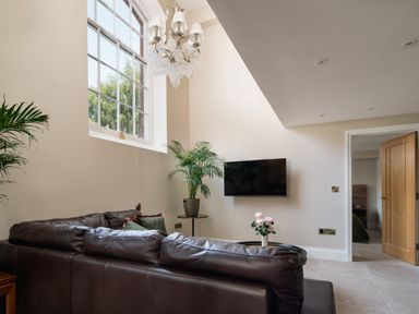A living room with a television and sofa at The School House in Newton Abbot
