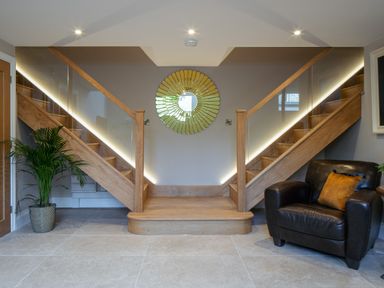 A hallway with stairs and a chair at The School House in Newton Abbot