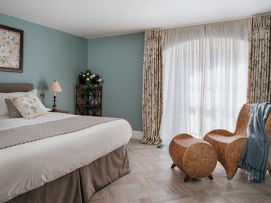 A bedroom with a bed and chairs at The School House in Newton Abbot