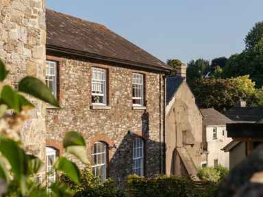 An outdoor view of buildings and greenery at The School House in Ashburton