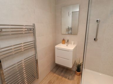 A bathroom with a towel rail and sink at Grange Cottage in Belford