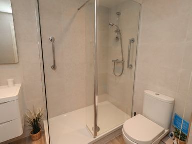 A bathroom with a shower and toilet at Grange Cottage in Belford
