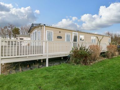 A mobile home with a deck in front at 62 Guddlebeck in Flookburgh