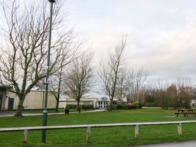 An outdoor view with trees and a building at 62 Guddlebeck in Flookburgh