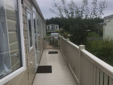 A pathway with a car and surrounding greenery at 62 Guddlebeck in Lakeland Leisure Park, Flookburgh