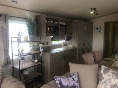 A living room with a kitchen unit and seating area at 62 Guddlebeck, Lakeland Leisure Park, Flookburgh