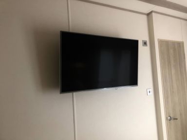 A wall-mounted television in a living room at 62 Guddlebeck, Lakeland Leisure Park, Flookburgh