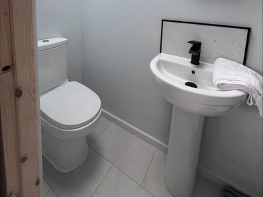 A bathroom with a toilet and sink at 81 Lon Gogarth in Benllech