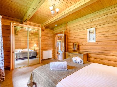 A bedroom with a bed and a mirror at Foresters Spa Plus in Dundee