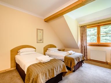 A bedroom with two single beds and a window at Foresters Spa Plus in Dundee