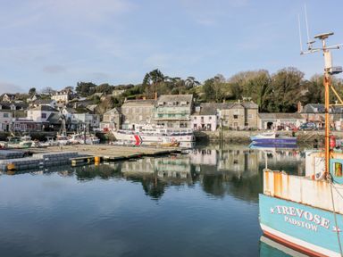 A harbor with boats and buildings reflected in the water at 65 Benasa Lodge, Winnard's Perch near St Columb Major