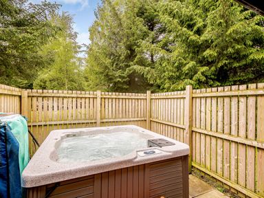 A hot tub surrounded by wooden fence and trees at Eagle Spa Plus in Dundee