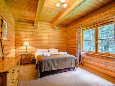 A bedroom with a bed and dresser at Foresters Spa Plus (Pet) in Dundee
