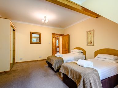 A bedroom with two beds and a mirror at Foresters Spa Plus (Pet) in Dundee