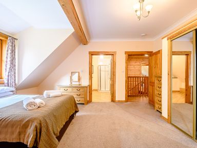 A bedroom with a bed and a mirror at Foresters Spa Plus (Pet) in Dundee