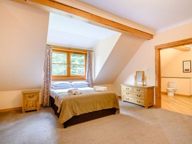 A bedroom with a bed and a dresser at Foresters Spa Plus (Pet) in Dundee