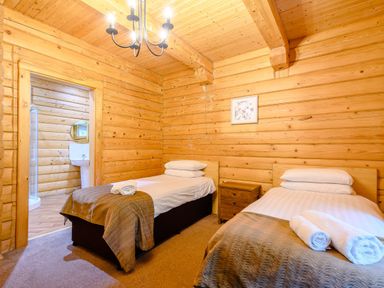 A bedroom with two beds and a door to a bathroom at Eagle Spa Plus (Pet) in Dundee
