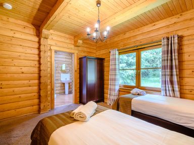 A bedroom with two beds and a wardrobe at Eagle Spa Plus (Pet) in Dundee