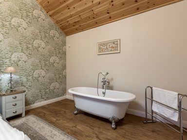 A bathroom with a bathtub and a towel rack at Byron Premier Spa (Pet) Dundee