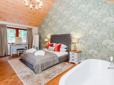 A bedroom with a bed and a tub at Byron Premier Spa (Pet) Dundee