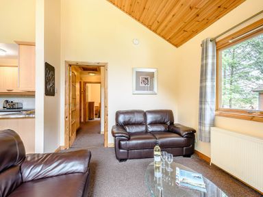 A living room with sofas and a table at Rainbow Lodge in Dundee