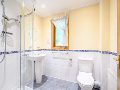 A bathroom with a shower and sink at Rainbow Lodge in Dundee
