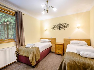 A bedroom with two beds and a window at Rainbow Lodge in Dundee