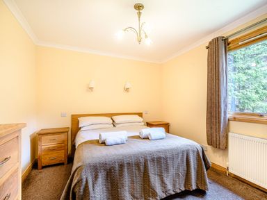A bedroom with a bed and bedside tables at Rainbow Lodge in Dundee