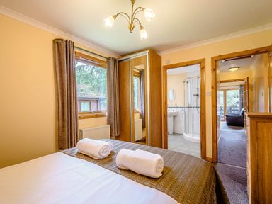A bedroom with a bed and towels on it at Rainbow Lodge in Dundee