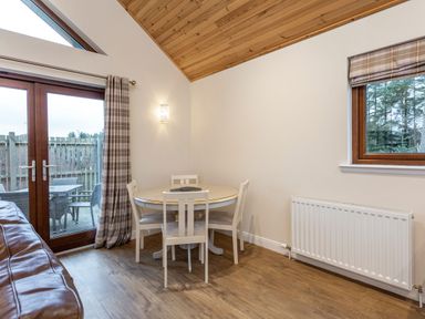 A dining room with a round table and chairs at Raeburn Premier Spa in Dundee