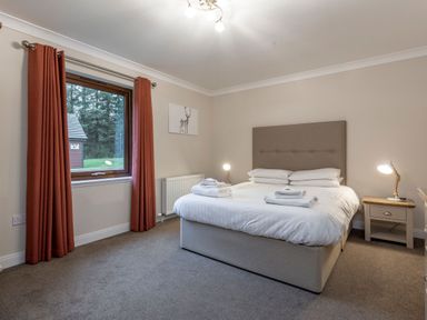 A bedroom with a bed and window at Raeburn Premier Spa in Dundee