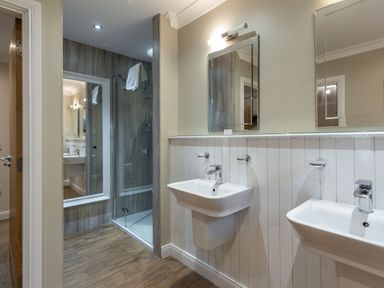 A bathroom with two washbasins and a shower enclosure at Raeburn Premier Spa in Dundee
