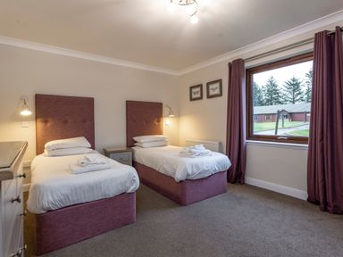 A bedroom with two beds and a window at Raeburn Premier Spa (Pet) Dundee