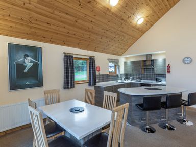 A kitchen with dining table and appliances at Rainbow Spa Plus in Dundee